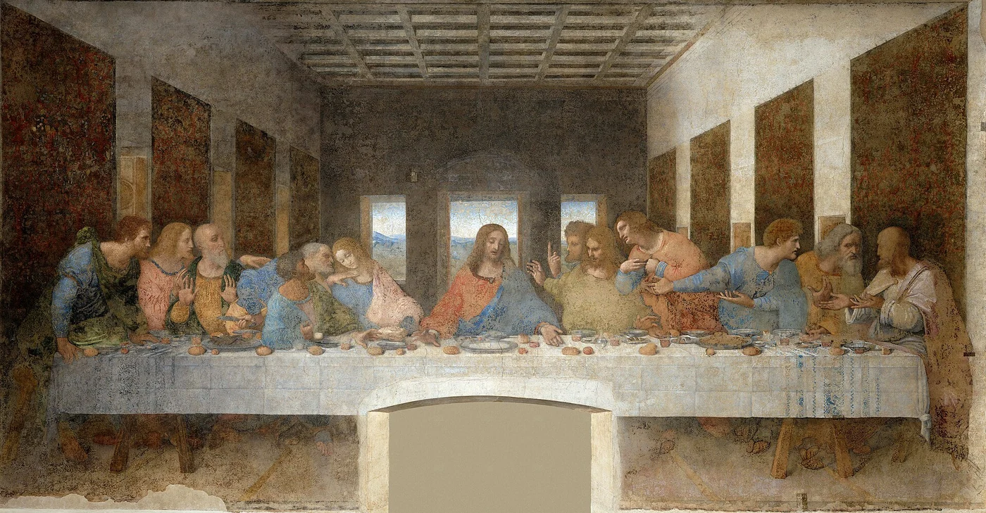 Jesus sits at the center of a long table while the twelve apostles respond with animated gestures during the Last Supper.